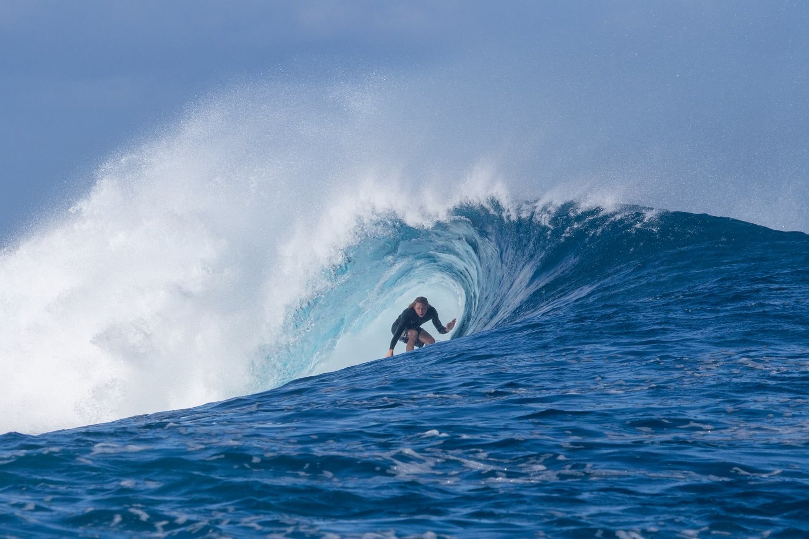 Seb crouched deep inside a blue barrel, looking out of the tube